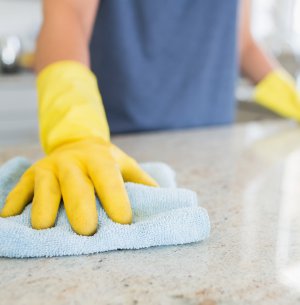 Woman cleaning the counter  in the kitchen